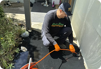 Drain Time Plumbing plumber working outside of a home