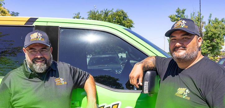 Drain Time plumbers standing in front of a service van