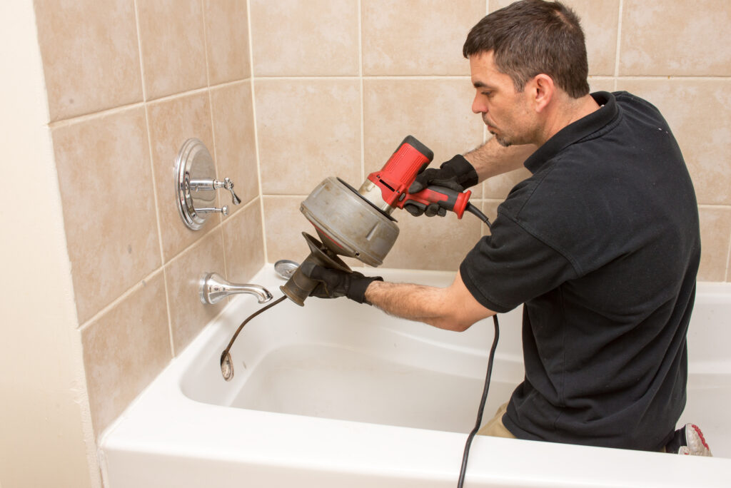 Plumber augering tub