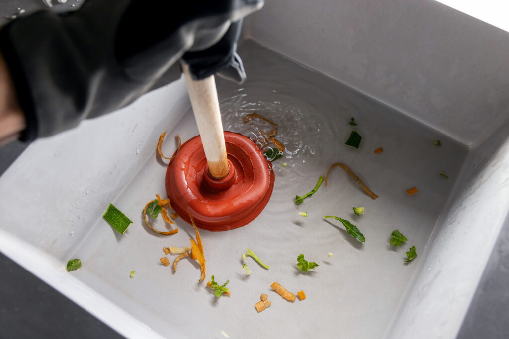 Plunging clogged kitchen sink drain